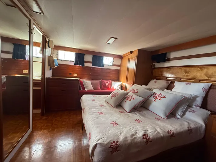 Aramis II Yacht Photos Pics Luxurious bedroom interior of 1990 Grand Banks 49 yacht with elegant bedding and wood finishes.