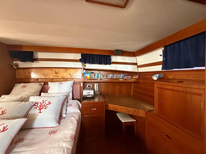 Aramis II Yacht Photos Pics Cozy cabin interior of 1990 Grand Banks 49 yacht with wooden decor and nautical bedding.