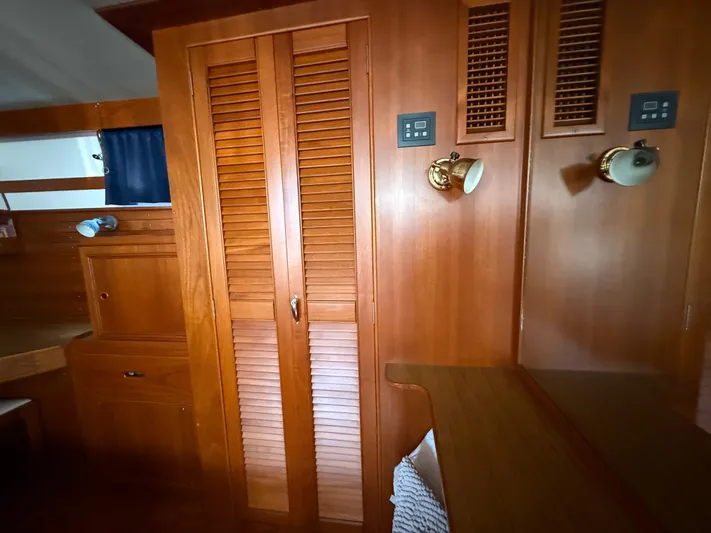 Aramis II Yacht Photos Pics Interior of 1990 Grand Banks 49 yacht with wooden cabinetry and brass lighting fixtures.