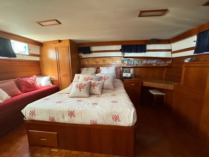 Aramis II Yacht Photos Pics Luxurious 1990 Grand Banks 49 yacht cabin with elegant wood finish and cozy bedding.