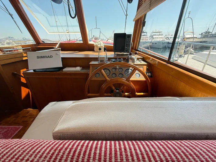 Aramis II Yacht Photos Pics Helm of 1990 Grand Banks 49 yacht with wooden steering wheel and navigation equipment.