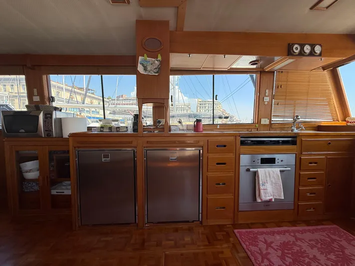 Aramis II Yacht Photos Pics Interior of 1990 Grand Banks 49 yacht kitchen with wooden cabinetry and modern appliances.