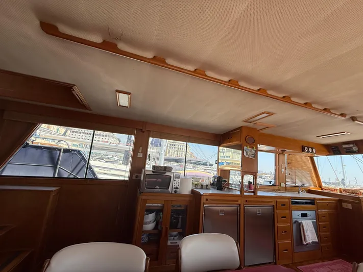 Aramis II Yacht Photos Pics Interior of a 1990 Grand Banks 49 yacht with wooden cabinetry and kitchen appliances.