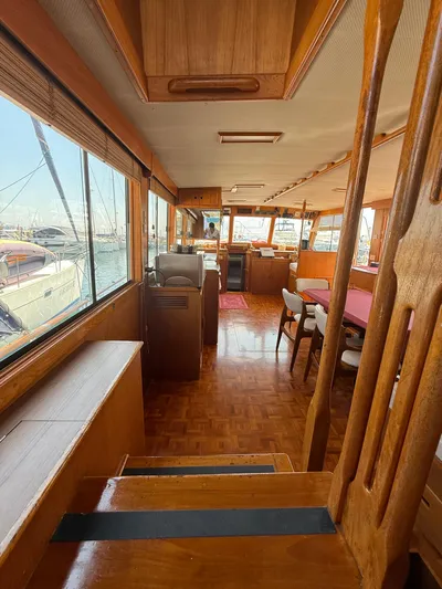 Aramis II Yacht Photos Pics Interior of 1990 Grand Banks 49 yacht with wooden furnishings and large windows.