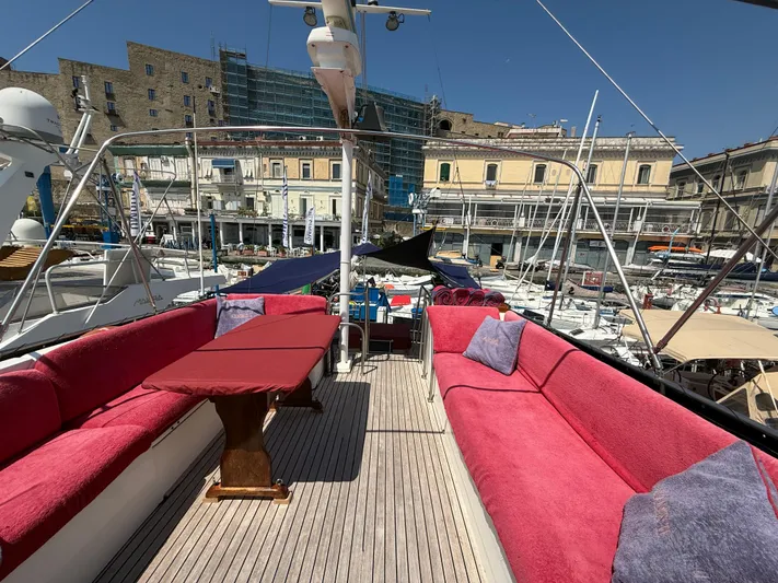 Aramis II Yacht Photos Pics Luxurious 1990 Grand Banks 49 yacht deck with red seating, docked in a marina.