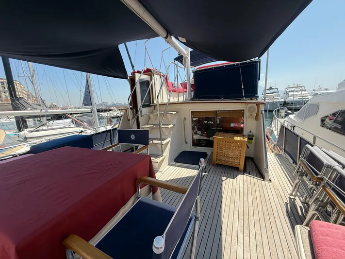 Aramis II Yacht Photos Pics 1990 Grand Banks 49 yacht deck with seating, table, and marina view.