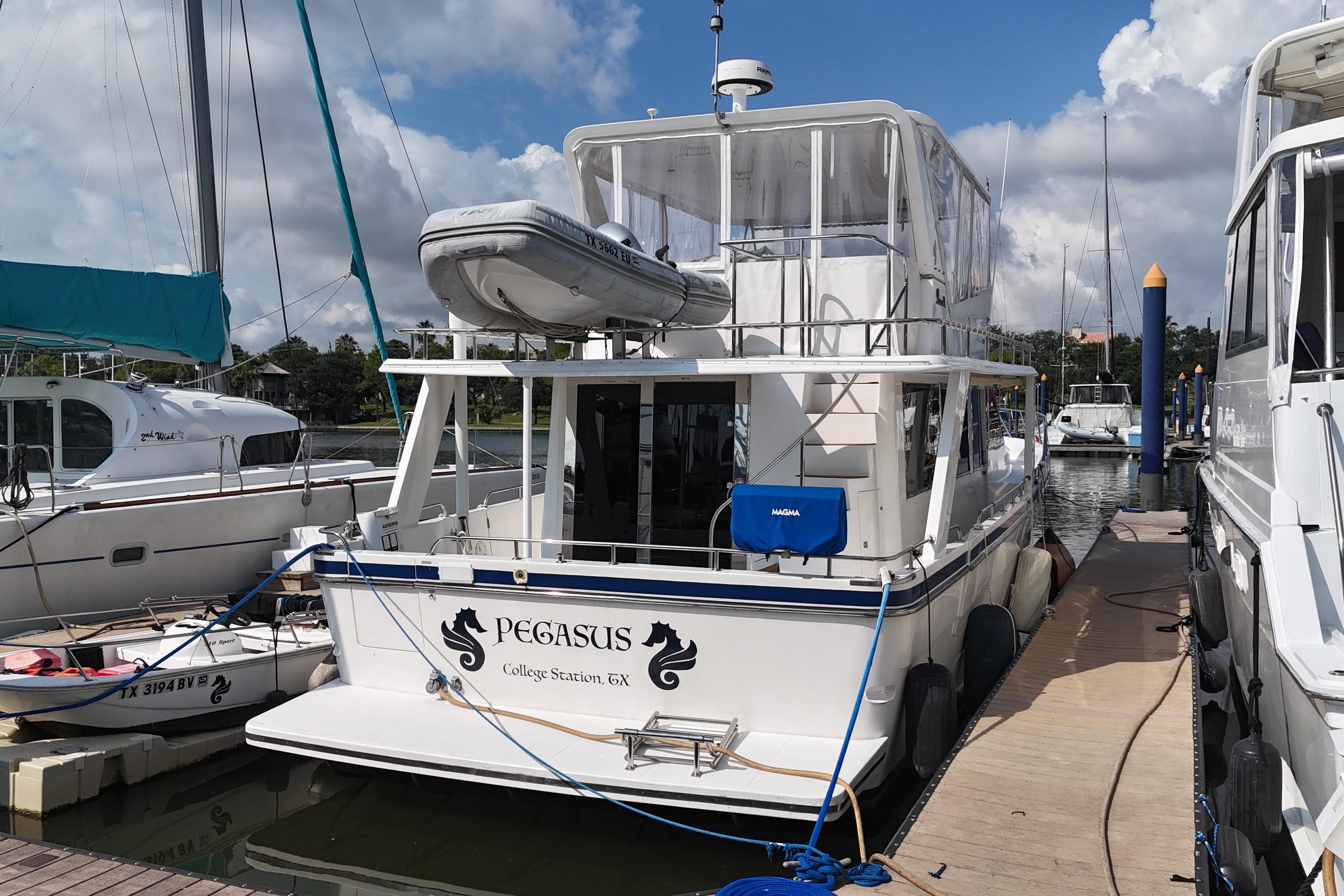 Prima 52 Seahorse 2001 yacht "Pegasus" docked at marina under cloudy sky.