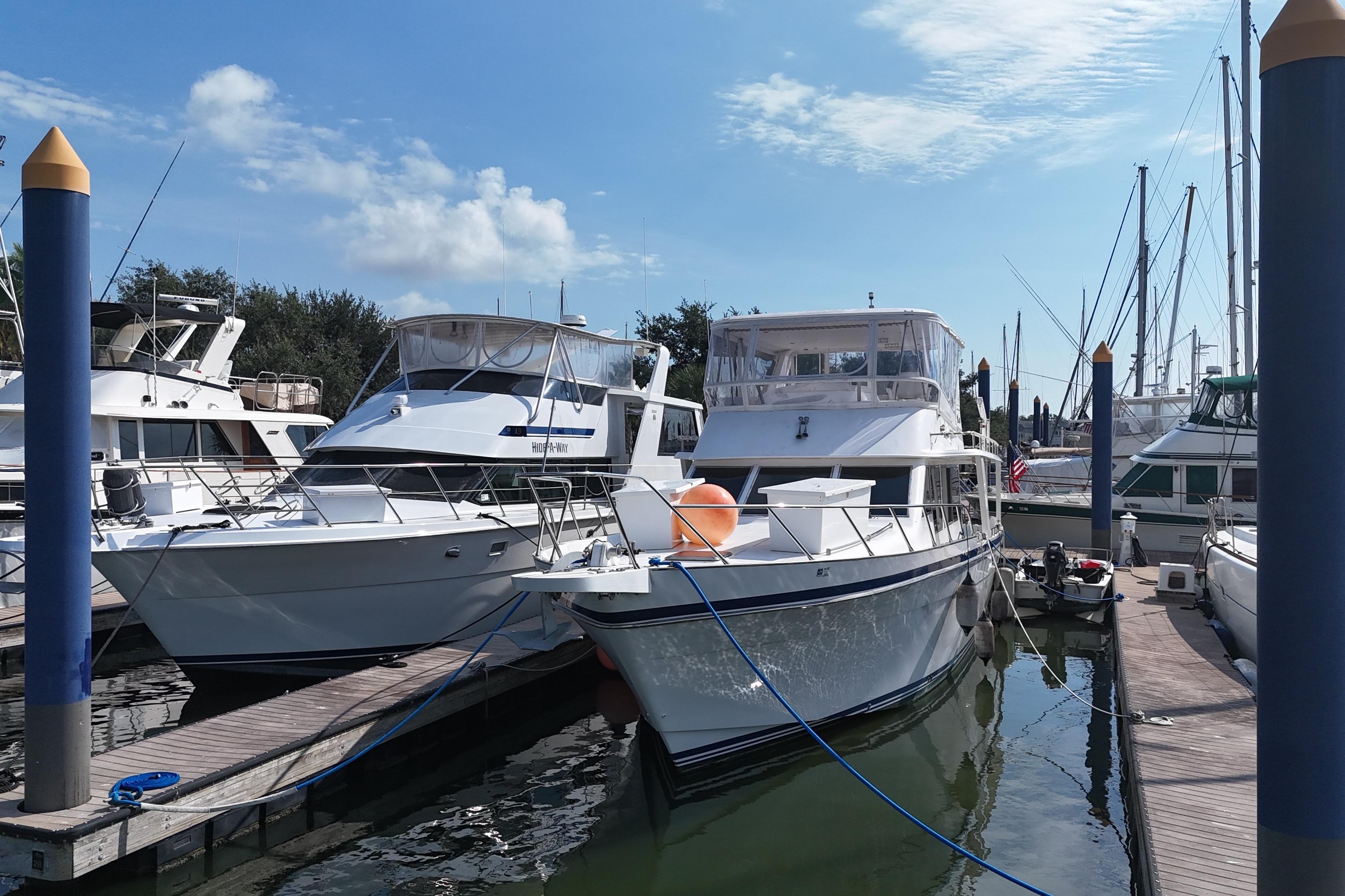 Boats docked at marina, featuring a 2001 Prima 52 Seahorse under a clear blue sky.