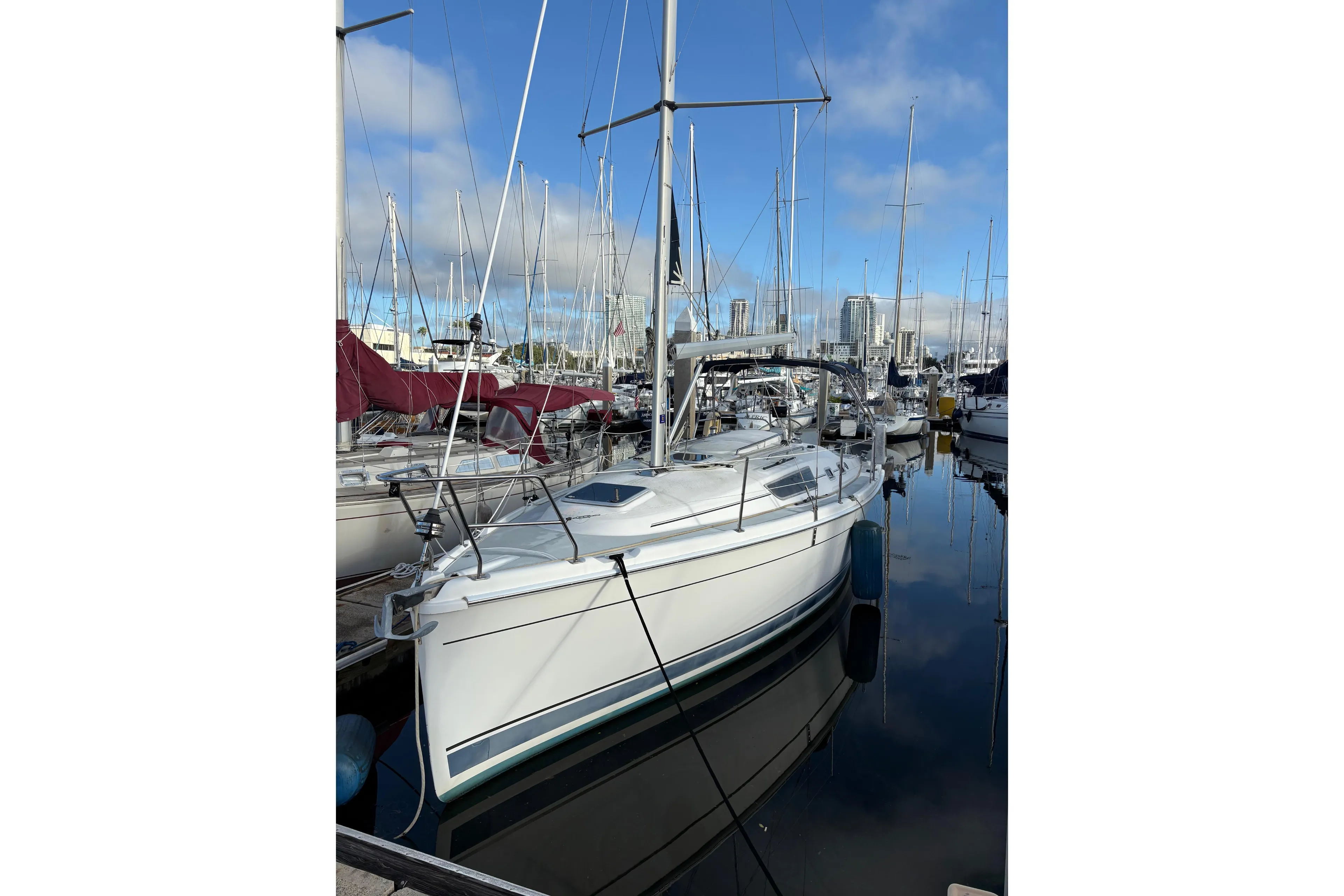 2009 Hunter 31-2 sailboat docked in a marina under a clear blue sky.