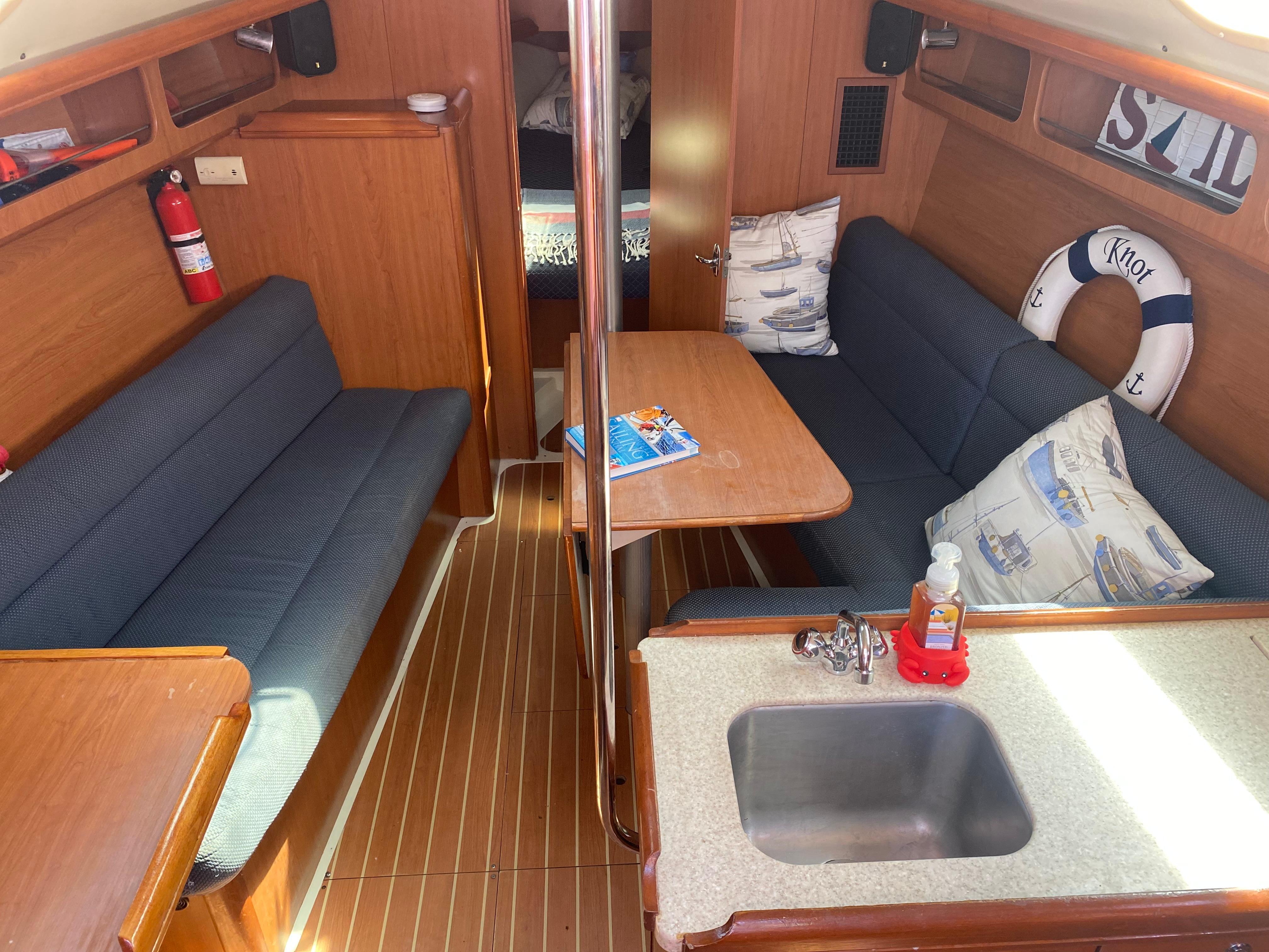 Interior of a 2009 Hunter 31-2 sailboat with seating, table, and kitchenette.
