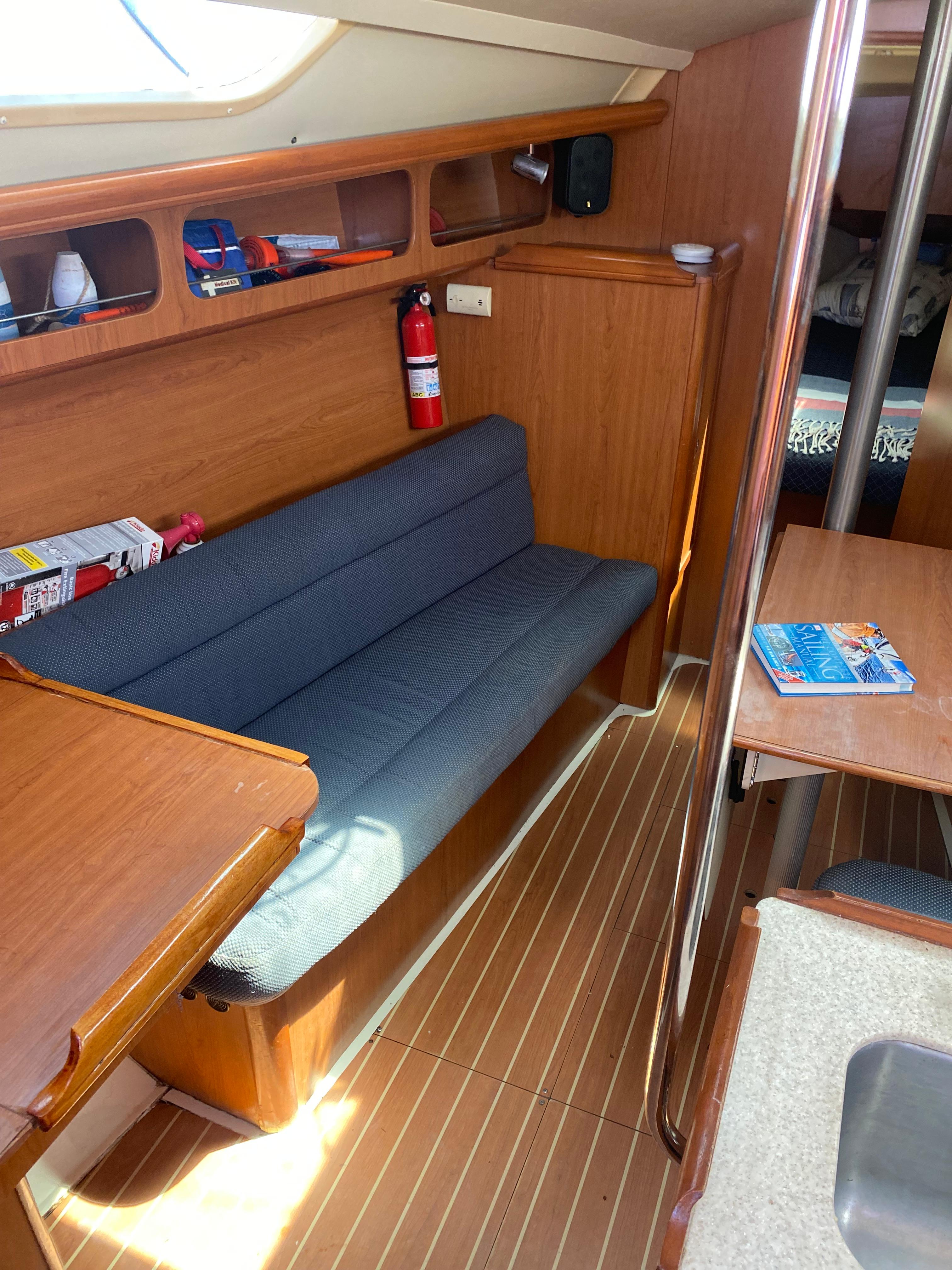 Interior of a 2009 Hunter 31-2 sailboat with wooden furnishings and a blue cushioned bench.