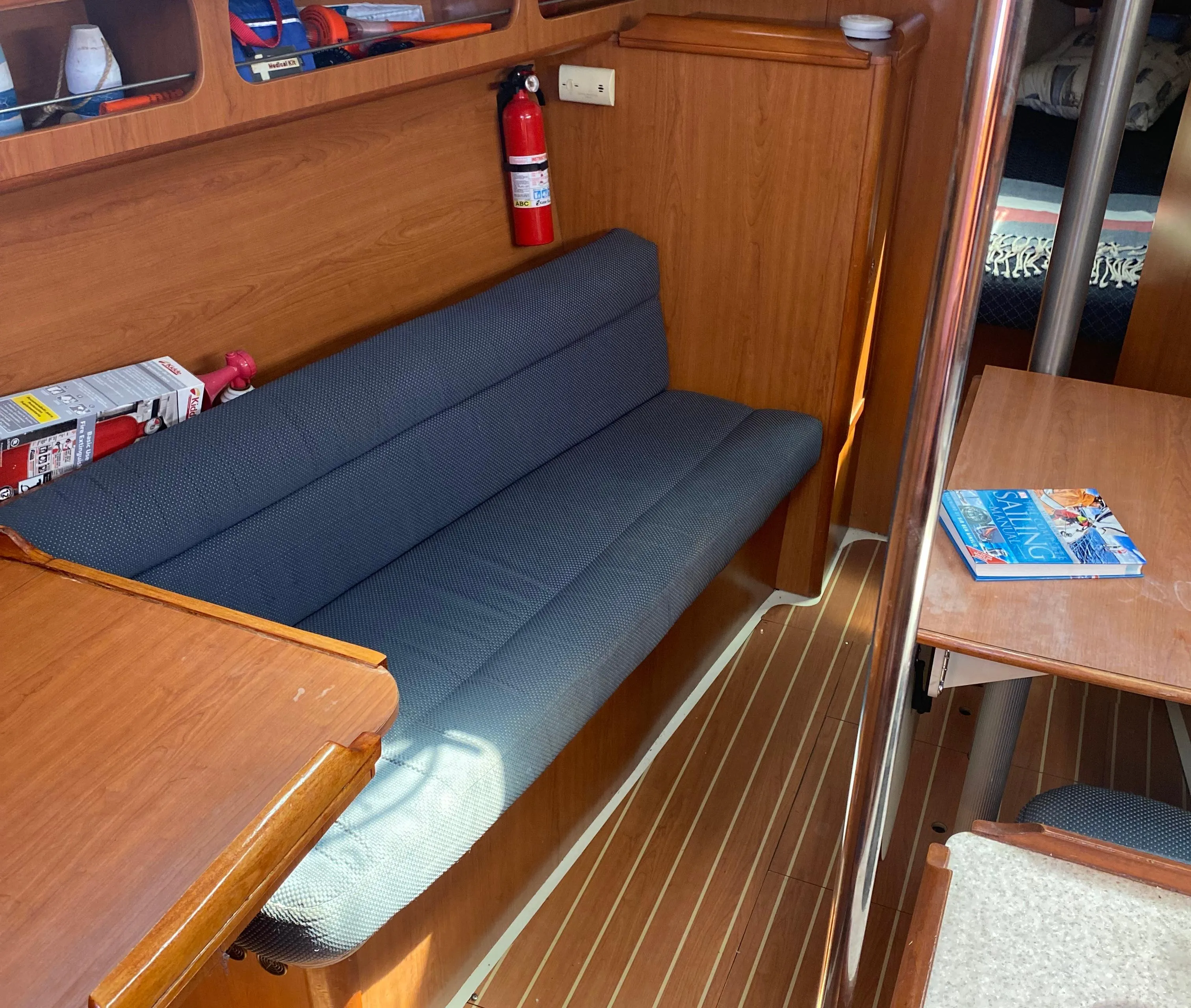 Interior of a 2009 Hunter 31-2 sailboat with wooden furnishings and a blue cushioned bench.