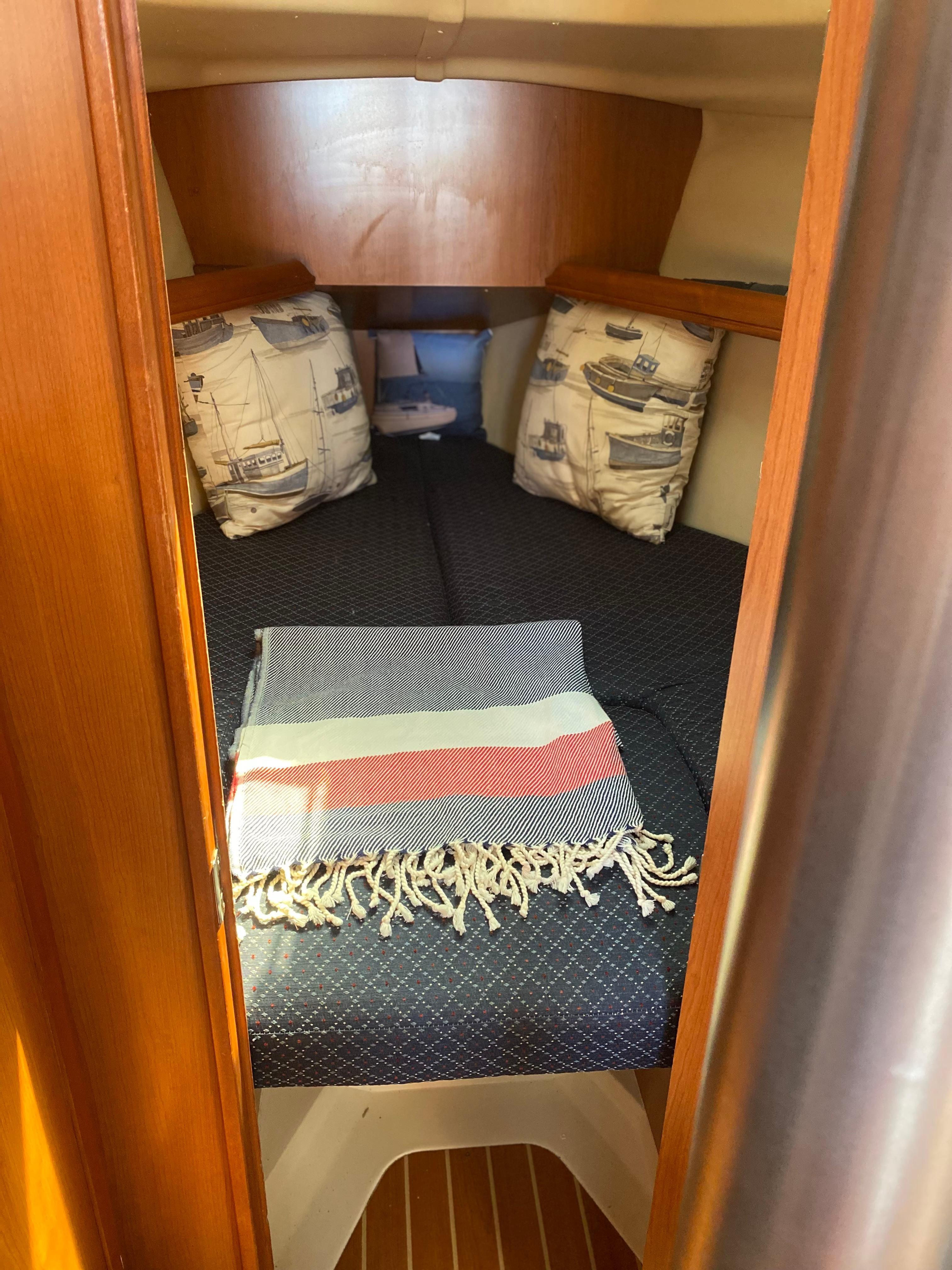 Cozy cabin interior of a 2009 Hunter 31-2 sailboat with nautical-themed pillows.
