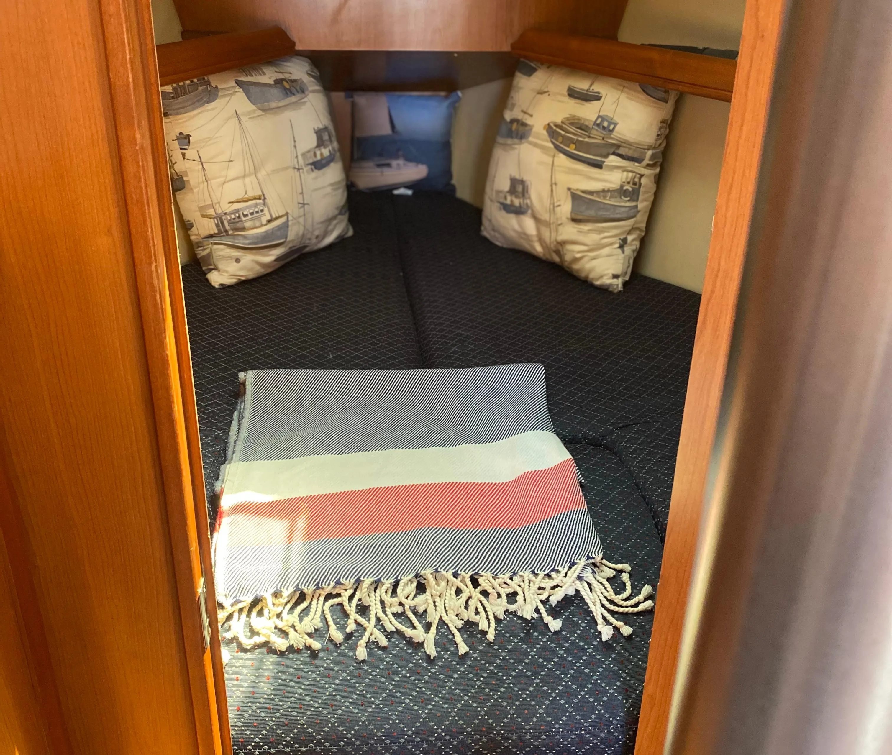 Cozy cabin interior of a 2009 Hunter 31-2 sailboat with nautical-themed pillows.