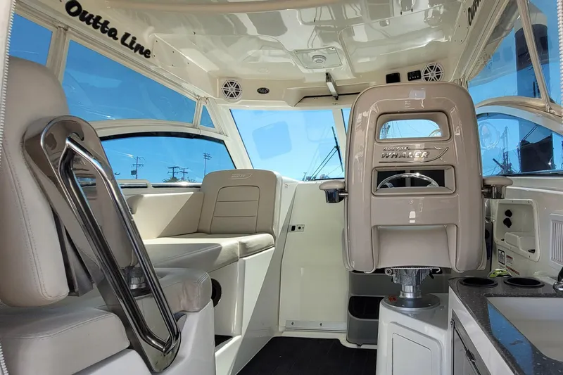 Outta Line Yacht Photos Pics Interior of a 2017 Boston Whaler 315 Conquest boat, featuring seating and helm.