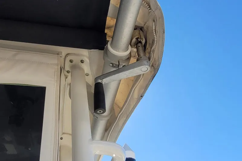 Outta Line Yacht Photos Pics Close-up of a 2017 Boston Whaler 315 Conquest boat canopy mechanism against blue sky.
