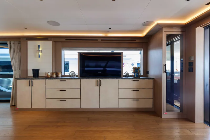 Heliophilia Yacht Photos Pics Luxurious interior of 2024 Sirena 88 yacht with modern cabinetry and entertainment center.