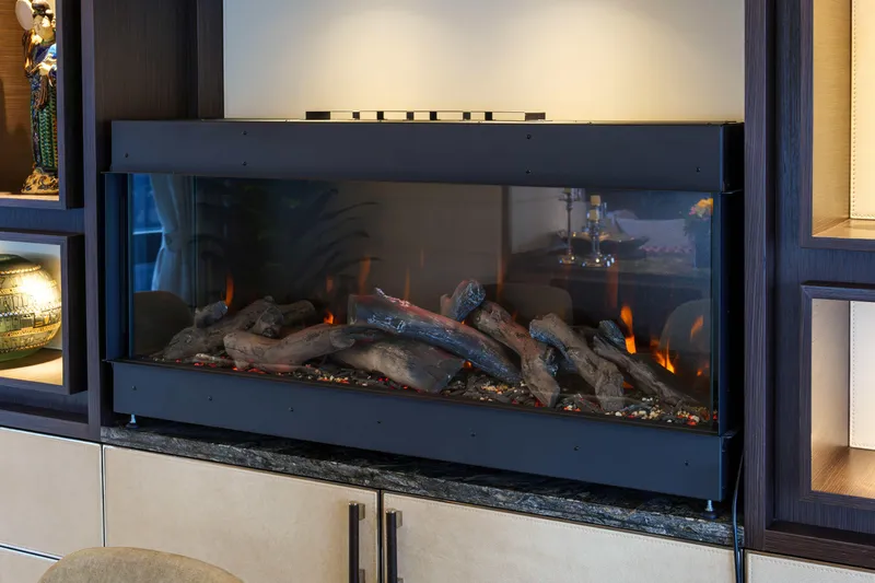 Heliophilia Yacht Photos Pics Modern electric fireplace with realistic logs in a stylish living room setting.