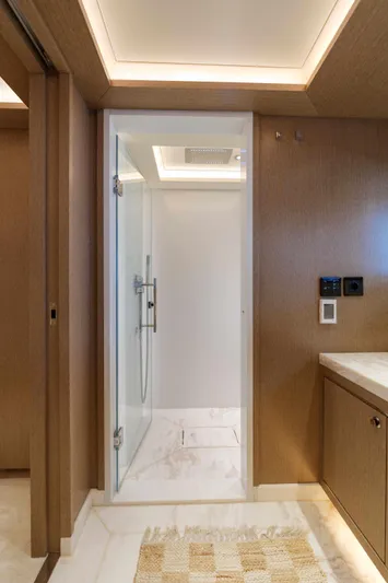 Heliophilia Yacht Photos Pics Luxurious bathroom in 2024 Sirena 88 yacht with modern shower and elegant wood paneling.