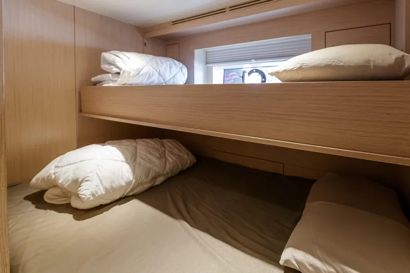 Heliophilia Yacht Photos Pics Bunk beds in 2024 Sirena 88 yacht cabin with wooden finish and cozy bedding.