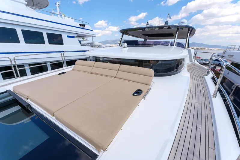 Heliophilia Yacht Photos Pics 2024 Sirena 88 yacht with spacious sun deck and luxurious seating under blue sky.