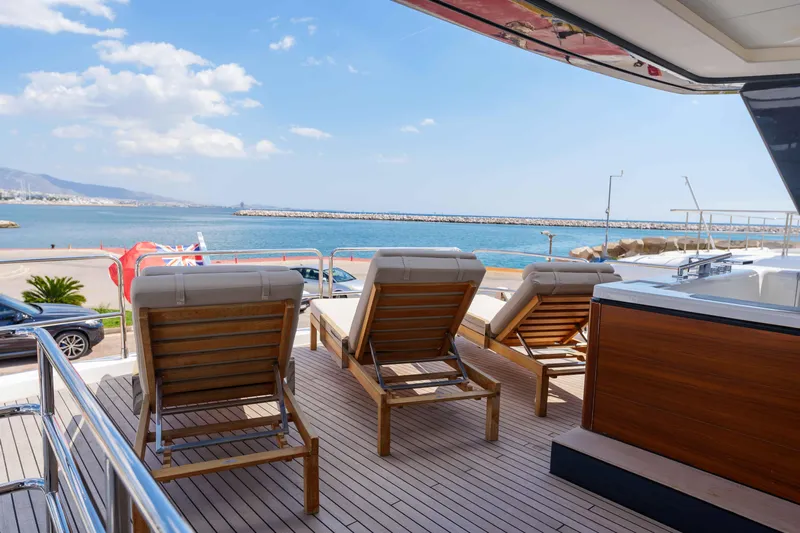 Heliophilia Yacht Photos Pics Luxury deck of 2024 Sirena 88 yacht with sun loungers and ocean view.