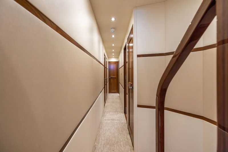 2020 Viking 80 Yacht Photos Pics Luxurious hallway inside 2020 Viking 80 Convertible yacht, featuring elegant wood accents and soft lighting.