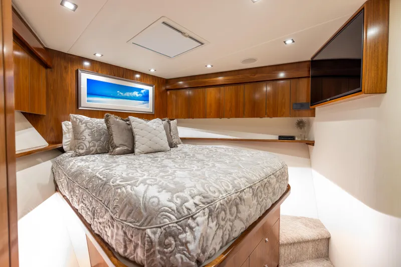 2020 Viking 80 Yacht Photos Pics Luxurious bedroom interior of 2020 Viking 80 Convertible yacht with elegant bedding and wood finishes.