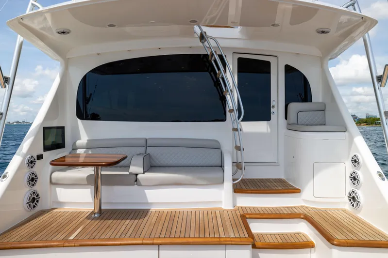 2020 Viking 80 Yacht Photos Pics 2020 Viking 80 Convertible yacht deck with seating, table, and ocean view.