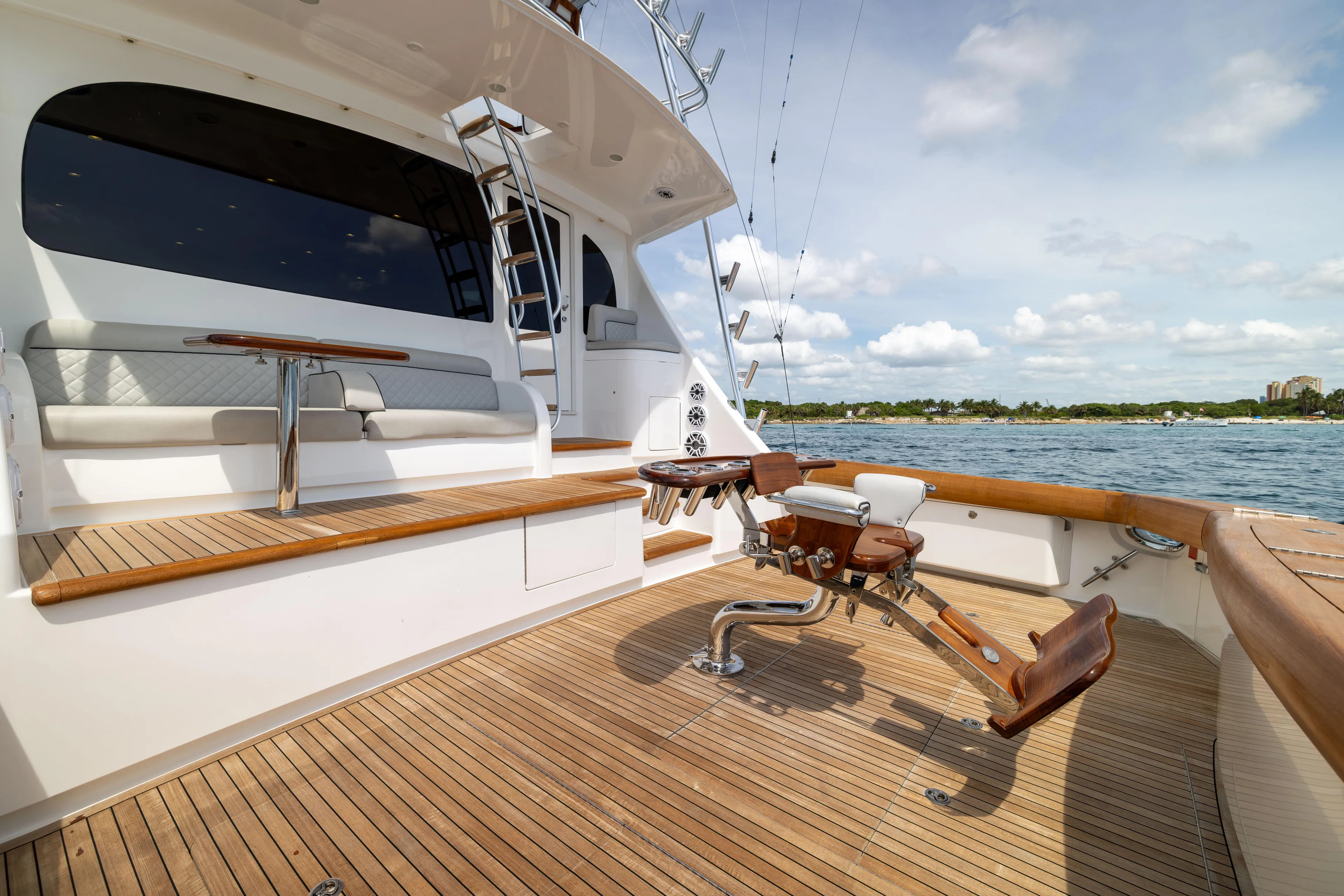 2020 Viking 80 Yacht Photos Pics 2020 Viking 80 Convertible yacht deck with seating and fishing chair, overlooking serene waters.