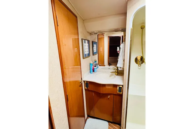  Yacht Photos Pics Luxurious bathroom in 2004 Viking 45 Convertible yacht with wooden cabinetry and modern fixtures.