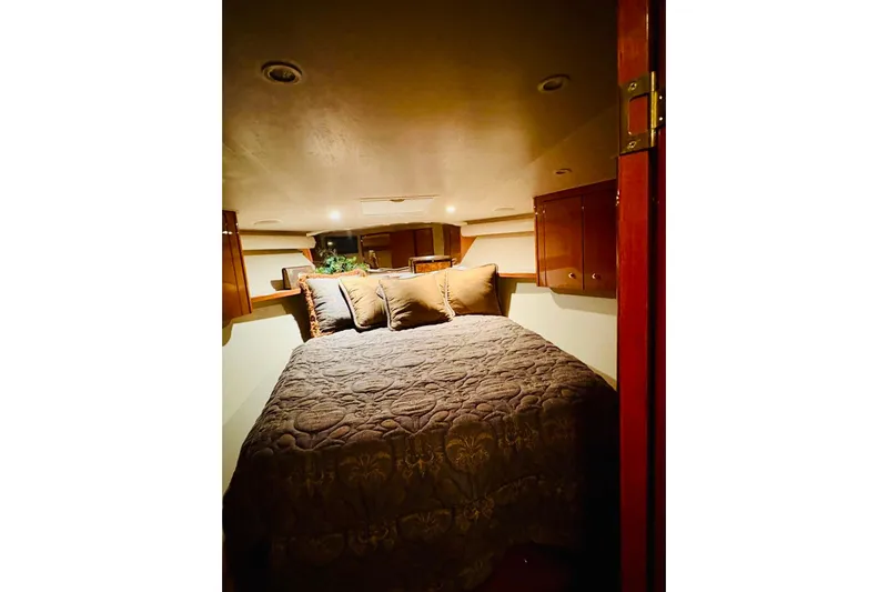  Yacht Photos Pics Cozy bedroom interior of 2004 Viking 45 Convertible yacht with plush bedding and wooden cabinets.
