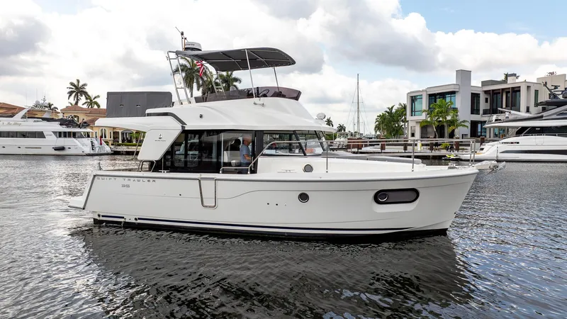 Unfiltered Yacht Photos Pics 2023 Beneteau Swift Trawler 35 cruising on a calm waterfront.