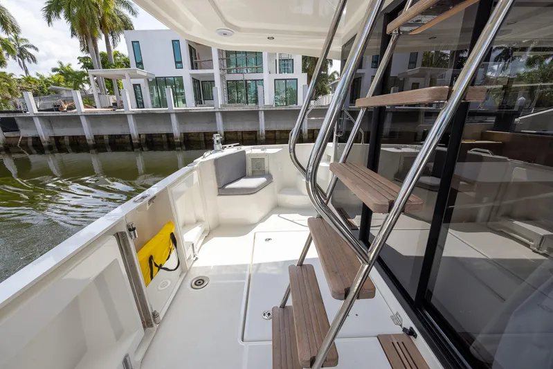 Unfiltered Yacht Photos Pics 2023 Beneteau Swift Trawler 35, spacious deck with modern seating and wooden stairs.