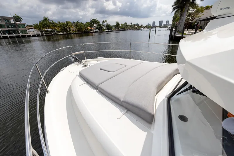 Unfiltered Yacht Photos Pics 2023 Beneteau Swift Trawler 35 on a scenic waterway, featuring a spacious deck with sunbed.