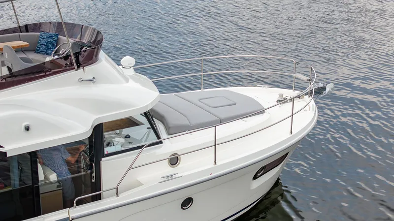 Unfiltered Yacht Photos Pics 2023 Beneteau Swift Trawler 35 on calm water, showcasing sleek design and spacious deck.