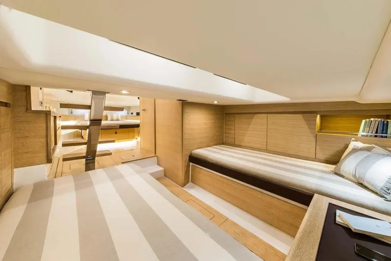  Yacht Photos Pics Luxurious interior of 2023 Pardo Yachts P43, featuring elegant wood finishes and cozy bedding.