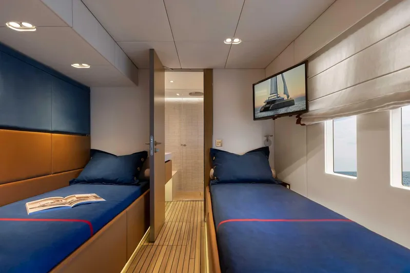  Yacht Photos Pics Luxurious cabin interior of 2026 Sunreef 80 Sunreef Power yacht with twin beds and TV.