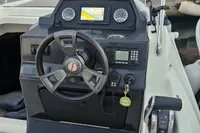 2017 Quicksilver 675 Sundeck boat dashboard with steering wheel and navigation system.