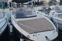 2017 Quicksilver 675 Sundeck boat docked in a marina, surrounded by other vessels.