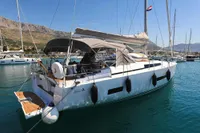 2022 Hanse 460 yacht docked in a scenic marina with mountains in the background.