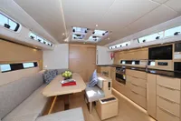 Luxurious interior of 2022 Hanse 460 yacht with modern kitchen and dining area.
