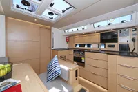 Modern kitchen interior of 2022 Hanse 460 yacht with wood finish and skylights.