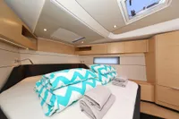 Luxurious cabin interior of 2022 Hanse 460 yacht with modern design and cozy bedding.