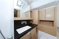 Modern bathroom interior of 2022 Hanse 460 yacht with sleek wood cabinetry.