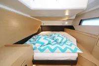 Cozy cabin interior of 2022 Hanse 460 yacht with chevron-patterned bedding.