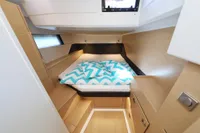 Cozy cabin interior of 2022 Hanse 460 yacht with modern wood finish and patterned bedding.