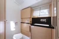 Modern bathroom interior on 2022 Hanse 460 yacht, featuring sleek wood cabinetry and compact design.
