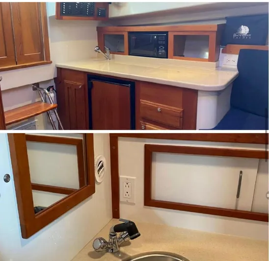Unity Yacht Photos Pics 2006 Back Cove 29 interior with kitchenette and sink, featuring wood cabinetry and modern amenities.