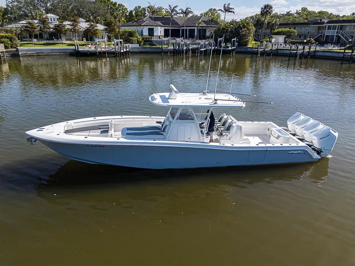  Yacht Photos Pics 2024 Invincible 39 Open Fisherman boat on calm water, showcasing sleek design and powerful engines.